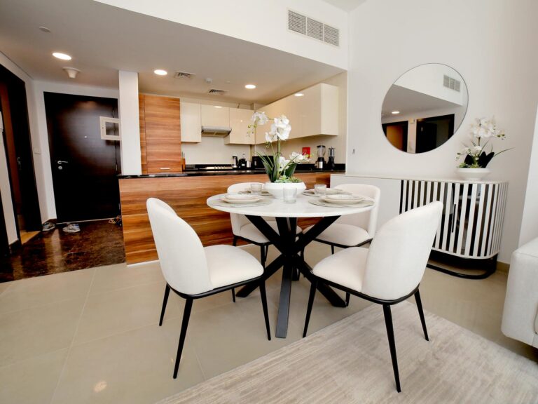 Bright and sleek kitchen with dining setup featuring modern decor and elegant furnishings.