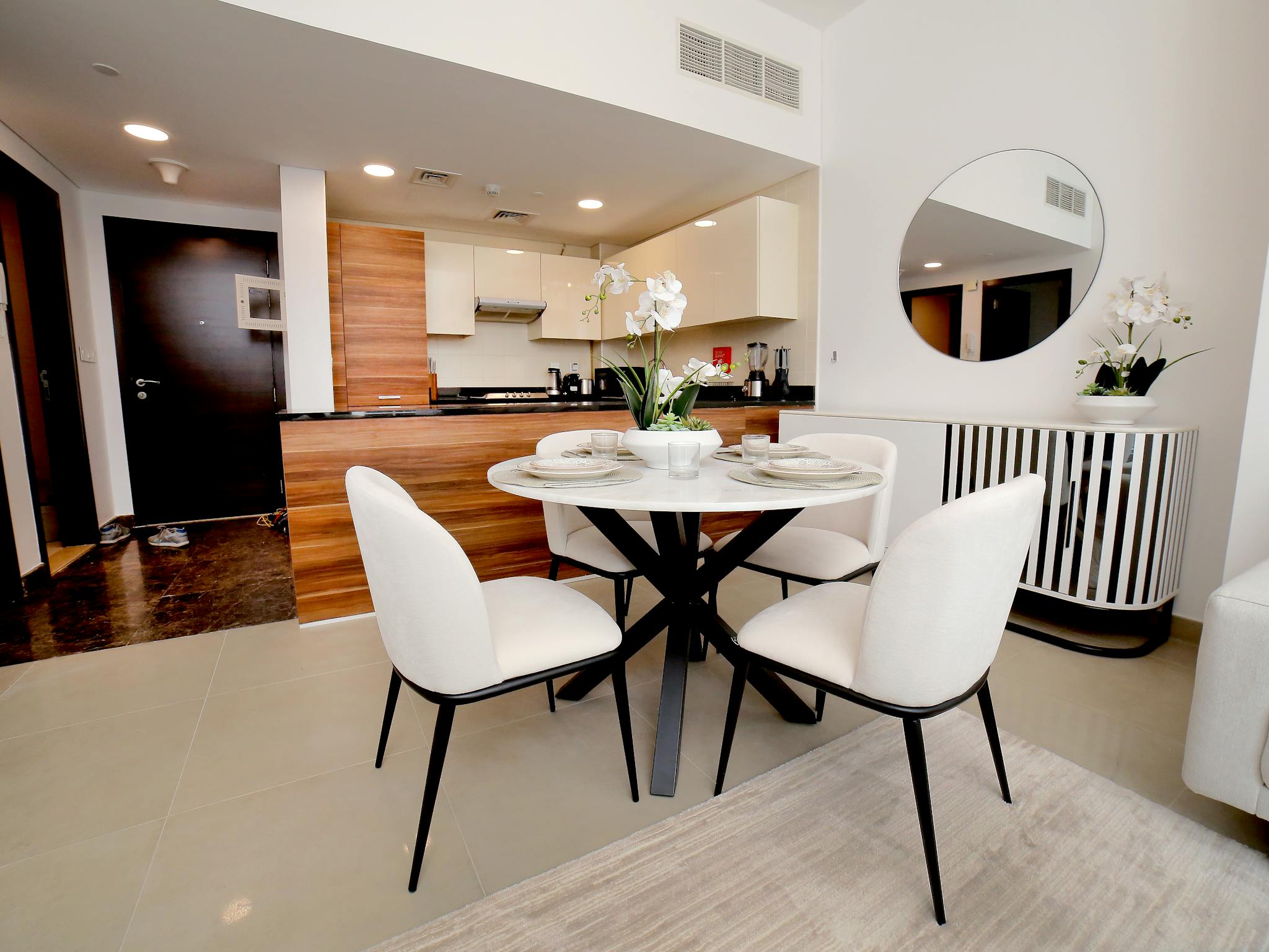 Bright and sleek kitchen with dining setup featuring modern decor and elegant furnishings.
