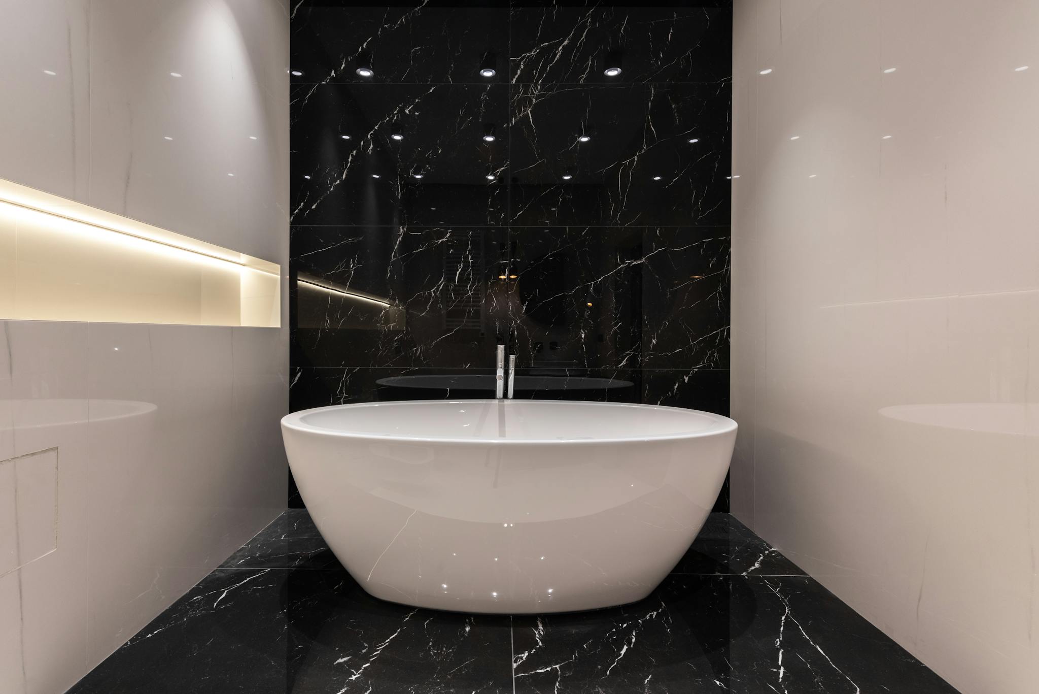 Elegant bathroom featuring a sleek marble bathtub in a contemporary setting, perfect for luxury living.