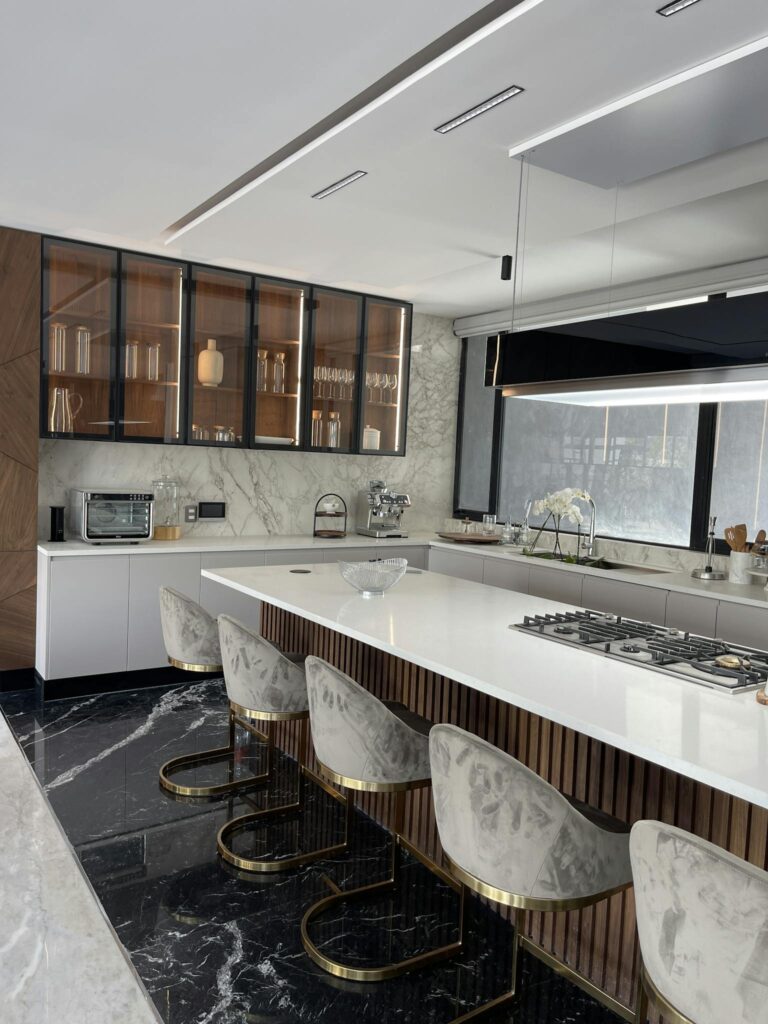 Elegant kitchen featuring a marble island, modern seating, and sleek cabinetry.